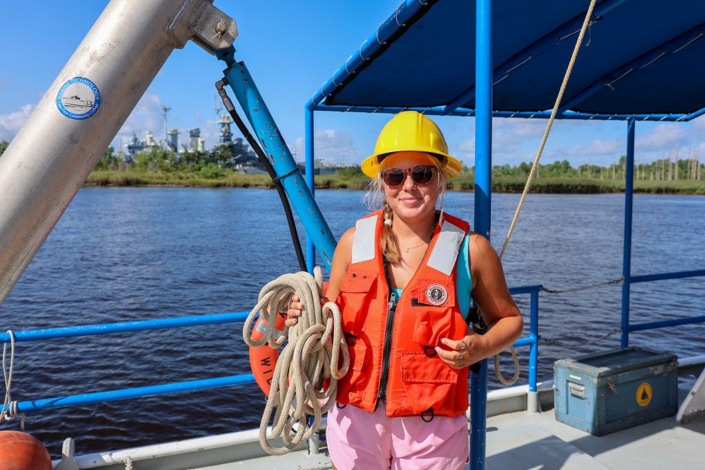 skyler wearing life vest on a boat on the cape fear river