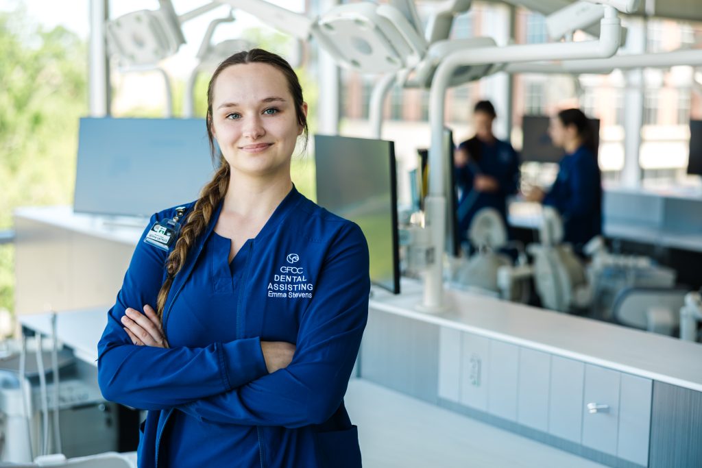 dental student in dental clinic smiling with arms crossed