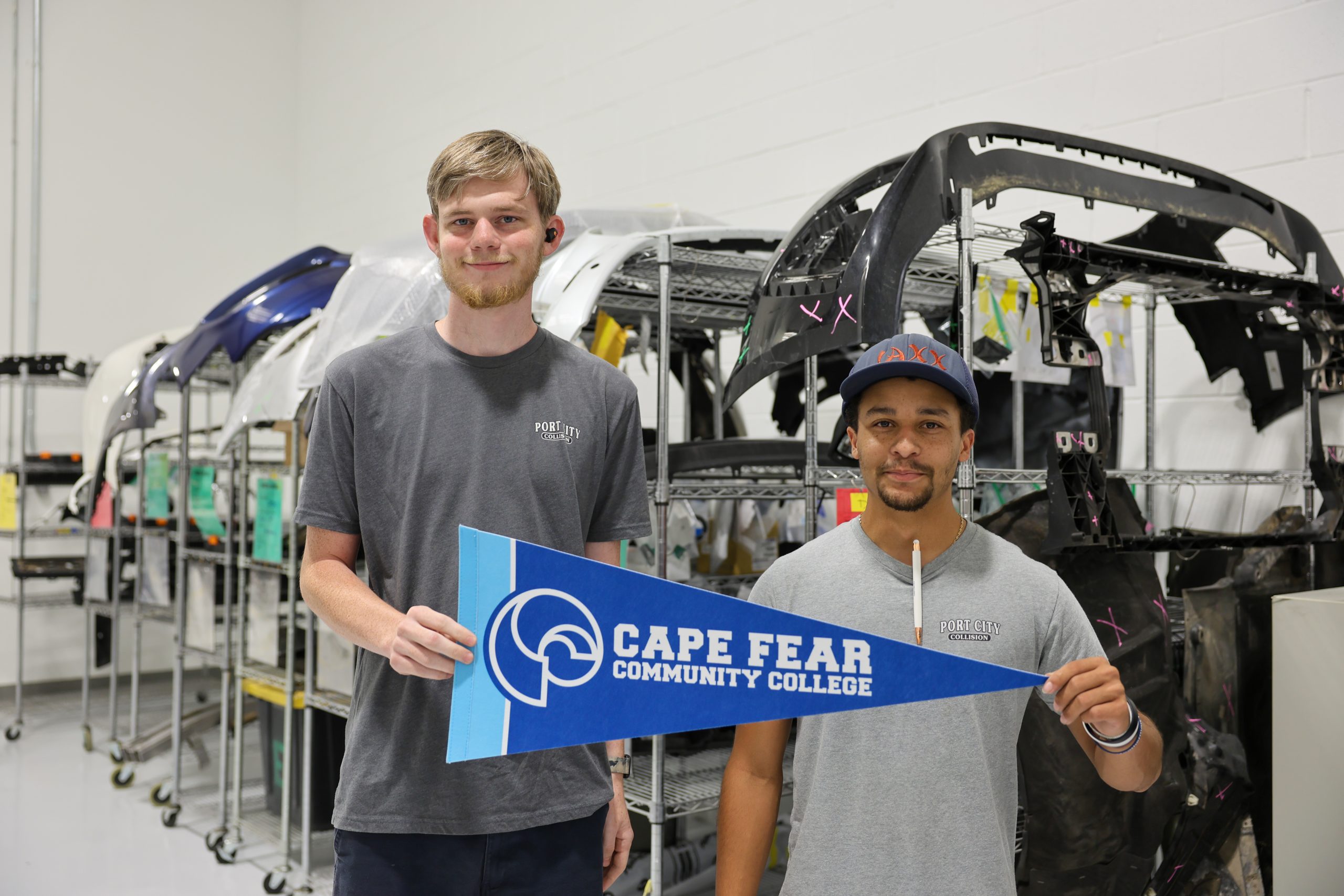 two auto techs holding cfcc flag in shop