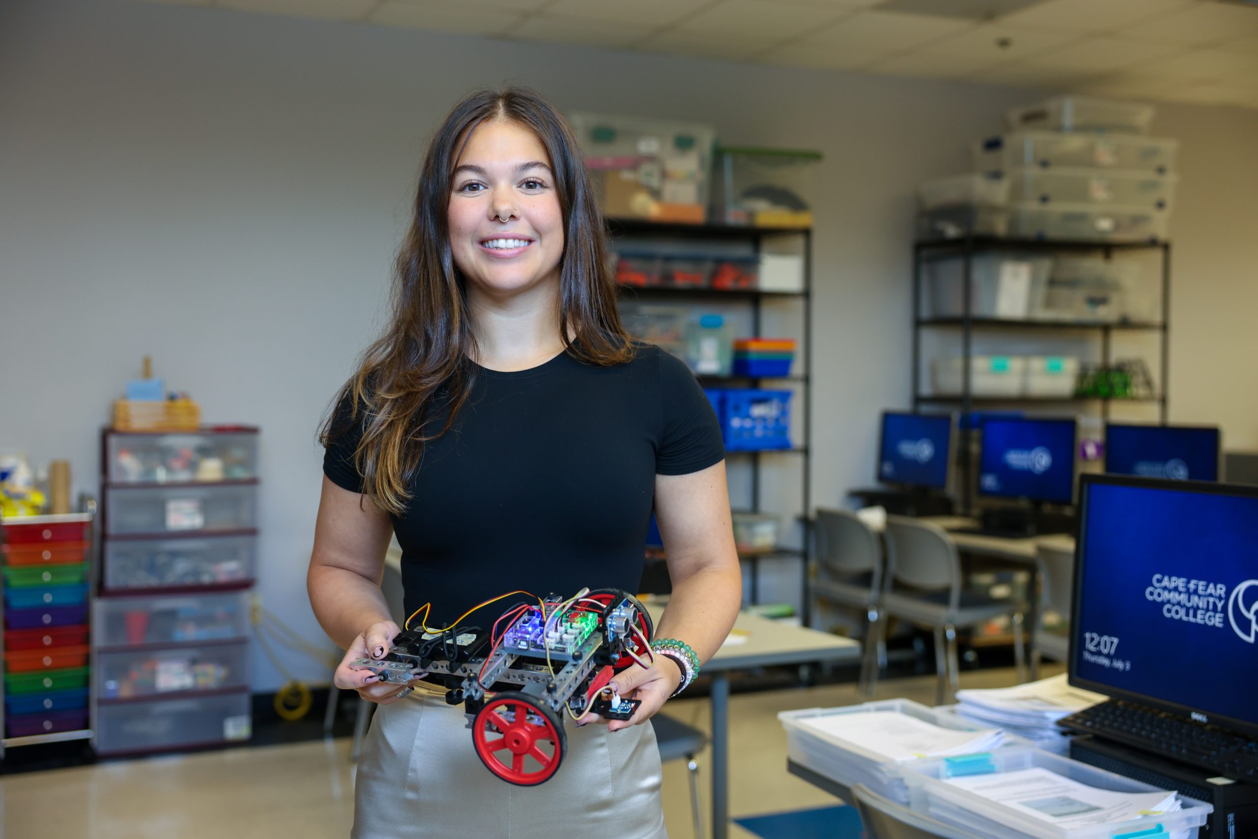 student engineer holding robot car