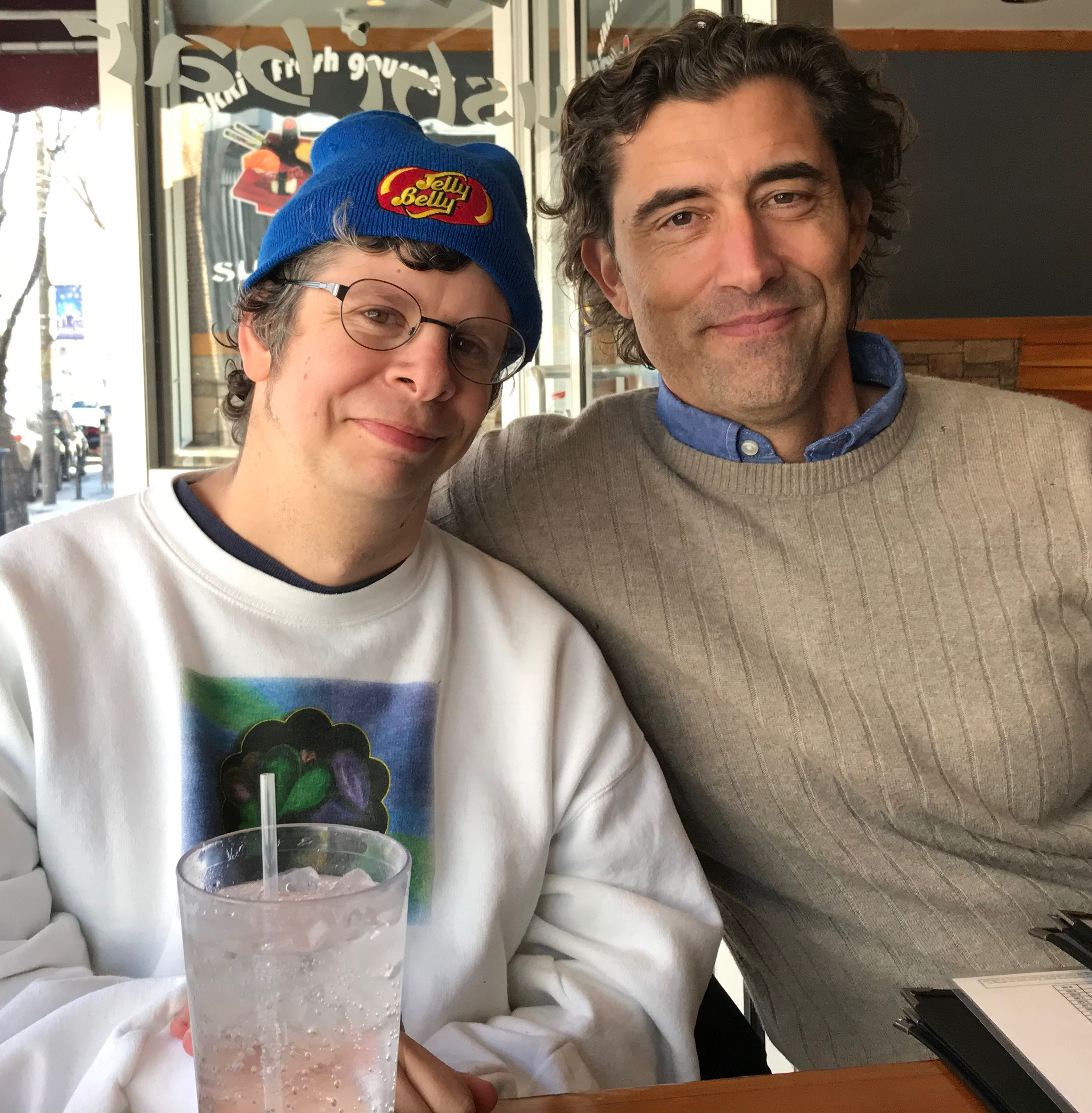two men sitting next to each at restaurant