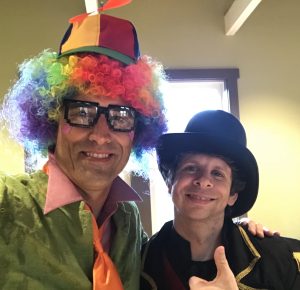 Two men in clown costumes smiling for camera