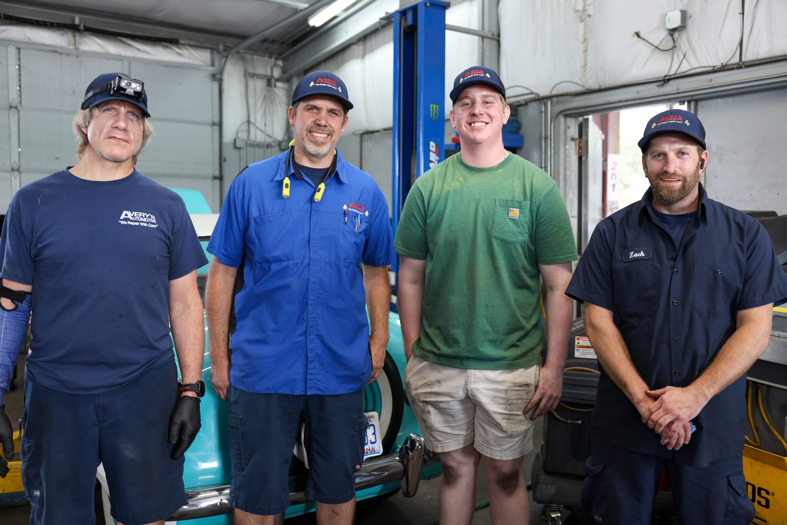 four auto techs in car shop