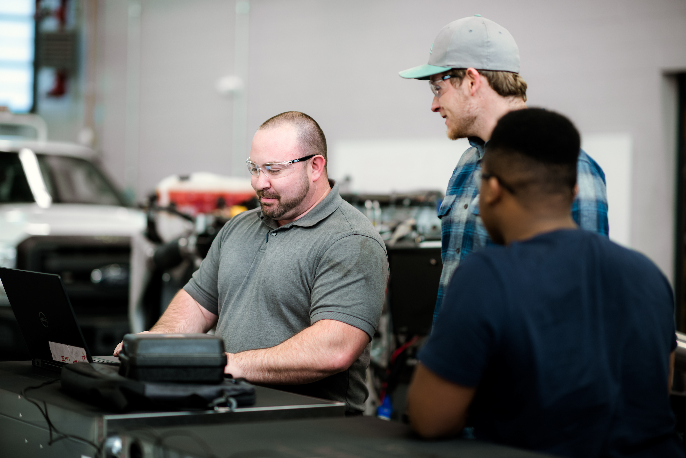 employee with students in diesel shop