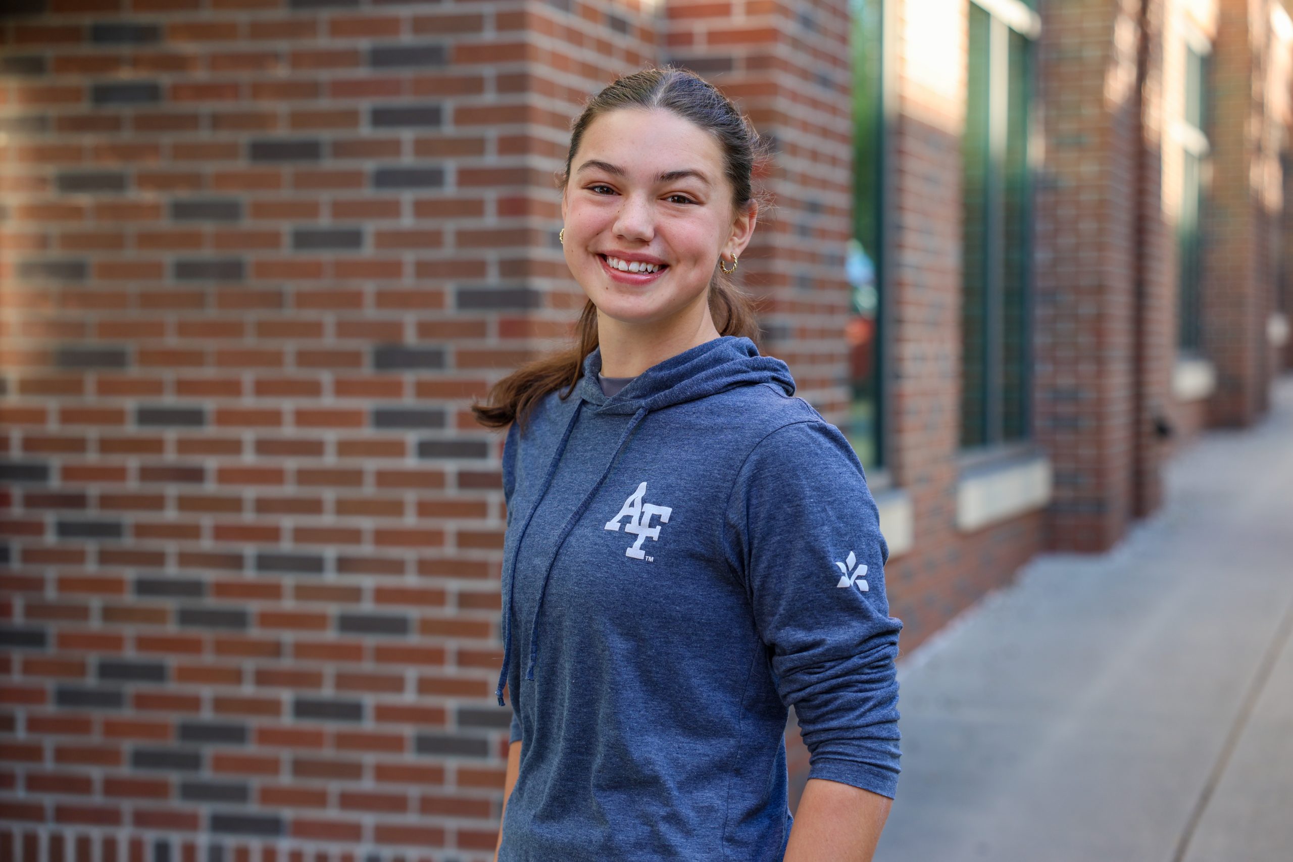 student standing on campus posing for picture