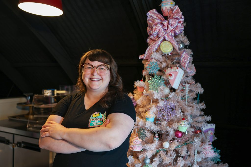 baker next to a christmas tree
