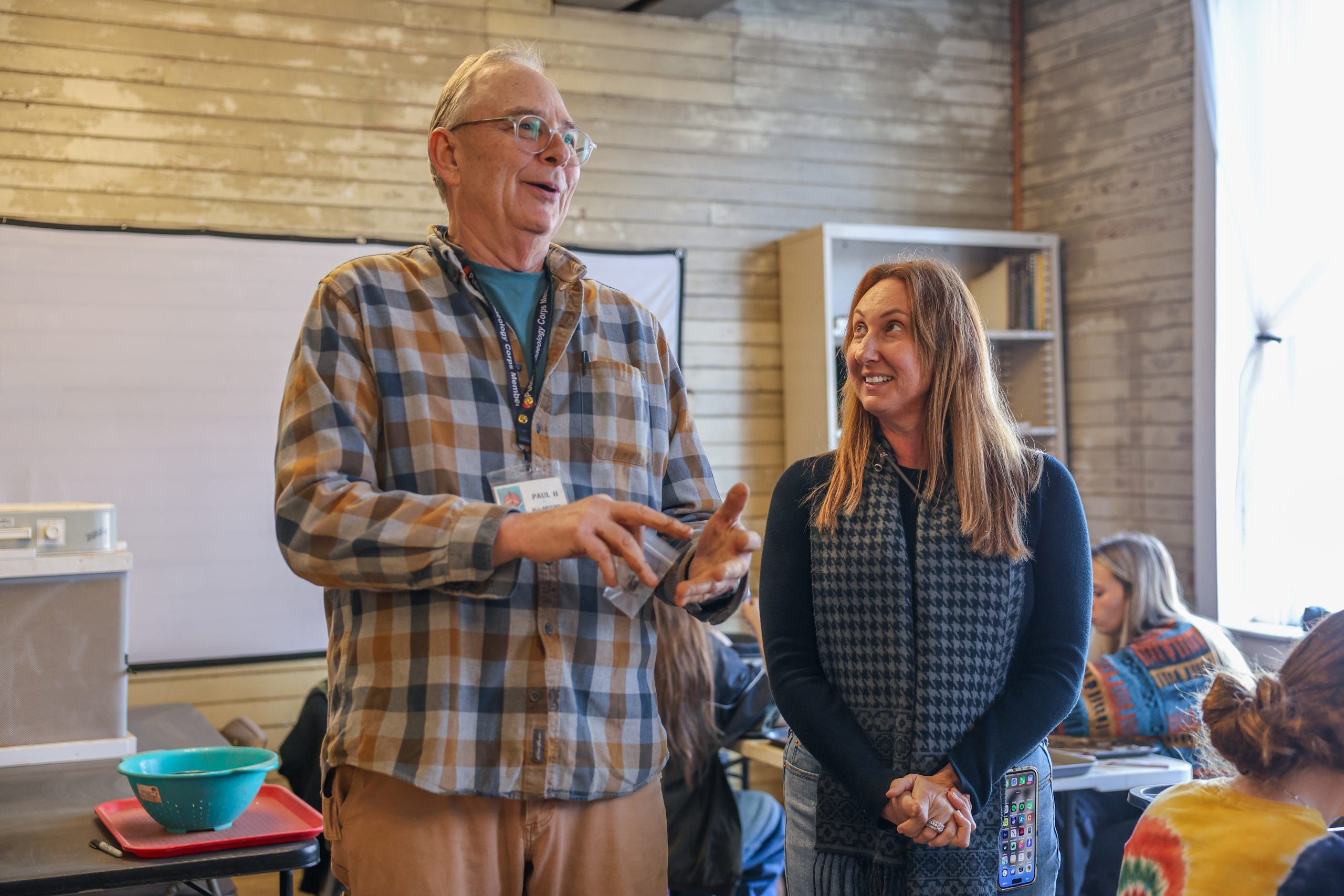 volunteer and faculty member speaking to a class at the lab