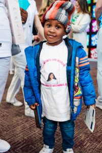 child cheering on his mom at pinning