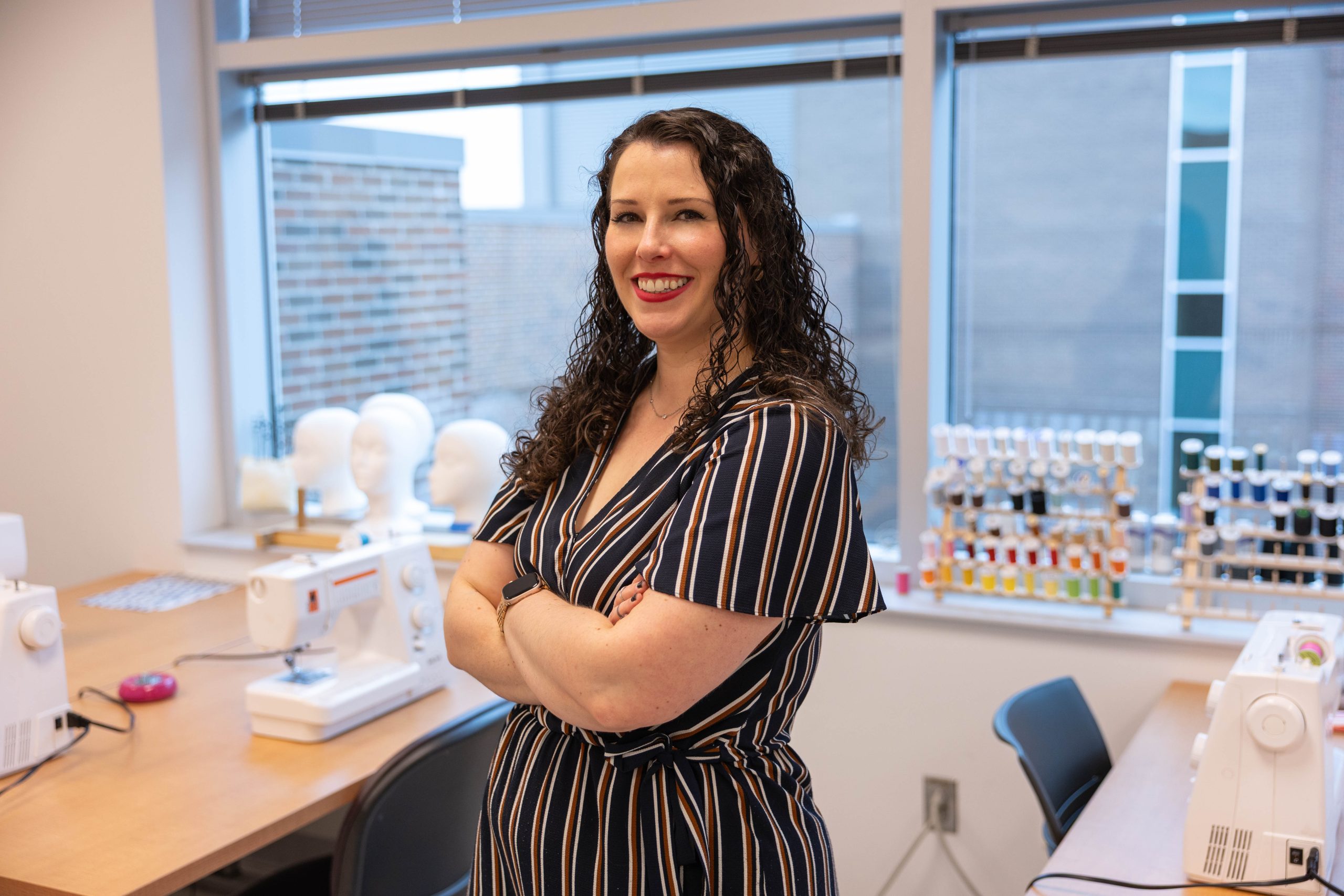 female standing in sewing classroom
