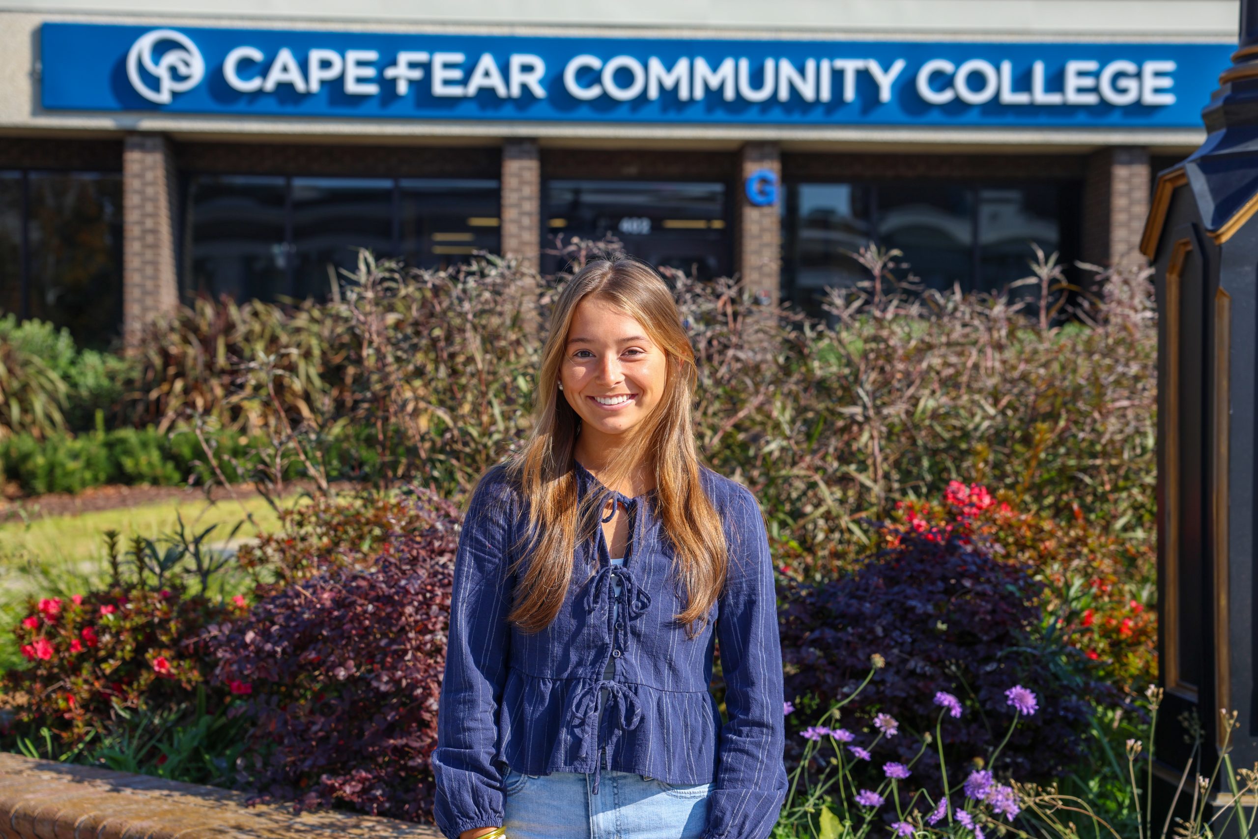 female standing in front of cape fear community college sign