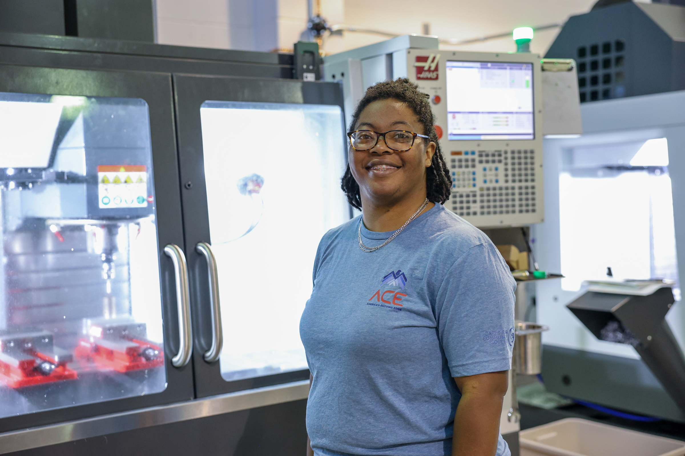 student in front of machine in machining shop