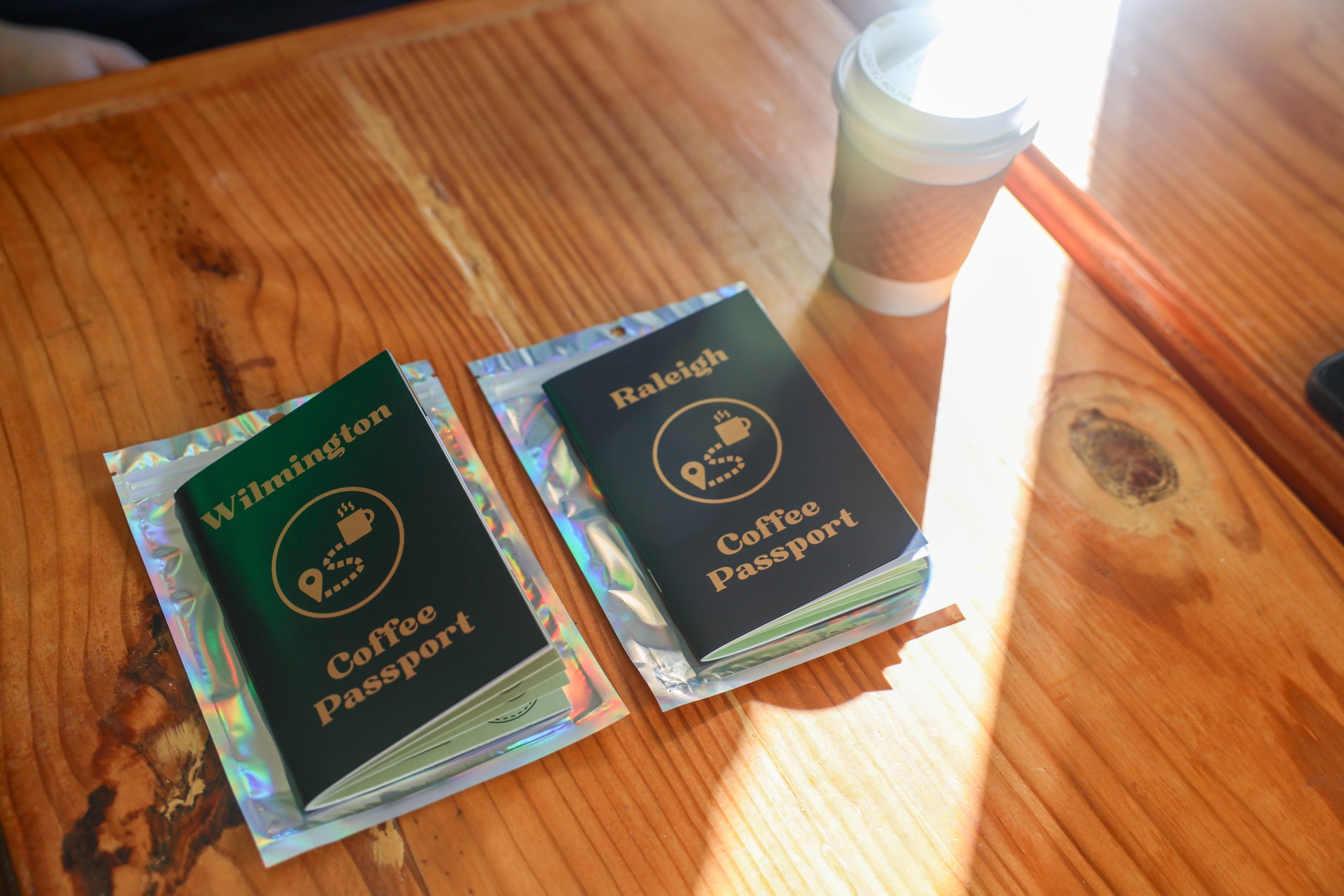 two coffee passports on a table next to a cup of coffe