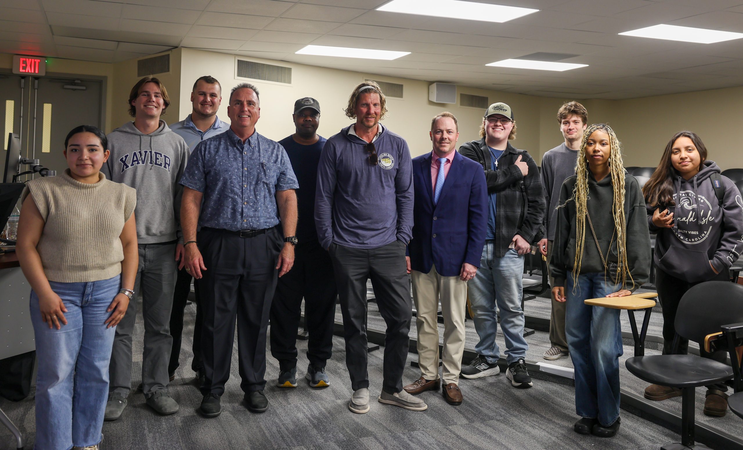 large group of students and staff posing for photo with speaker