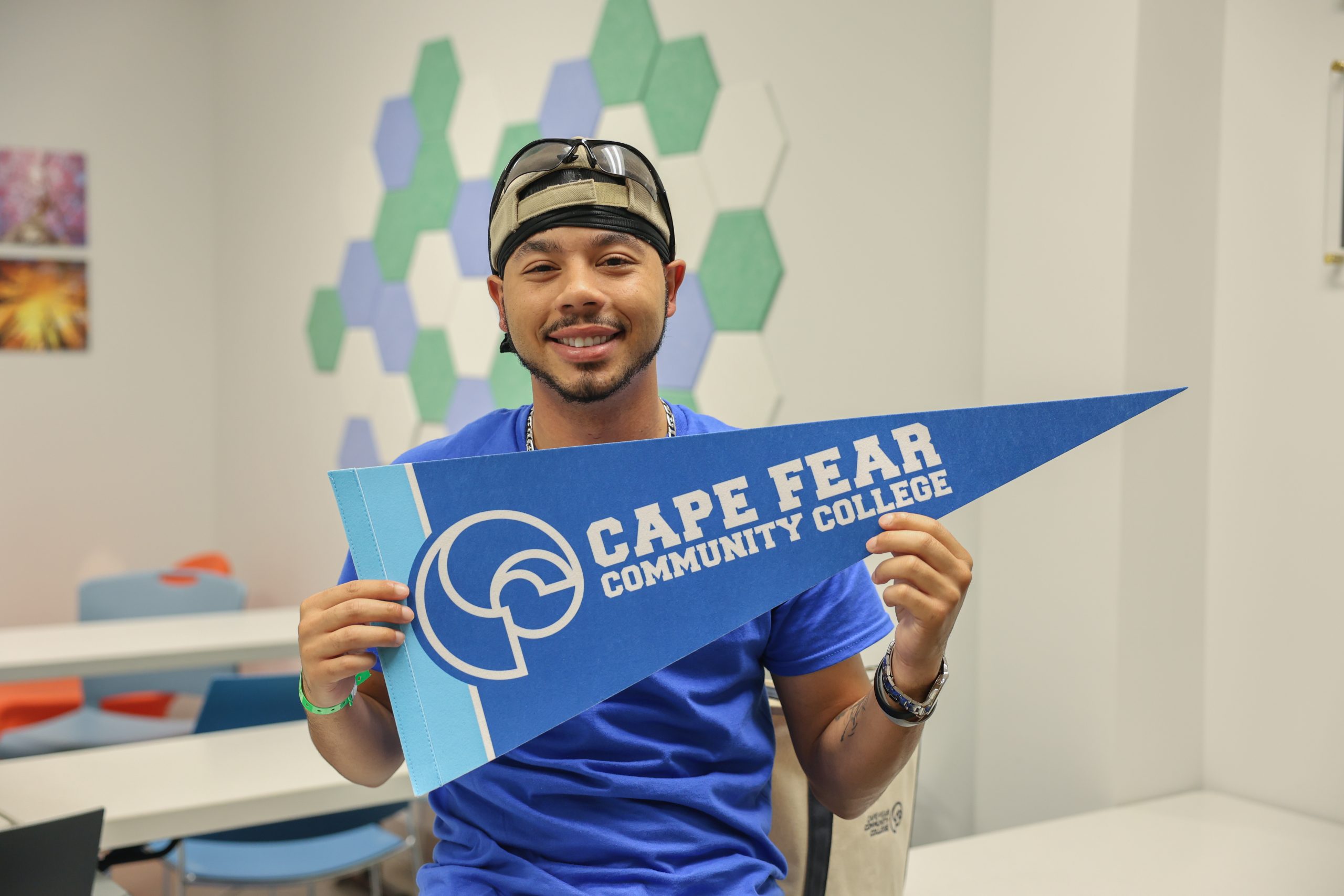 Isaiah holding cfcc pennant in classroom