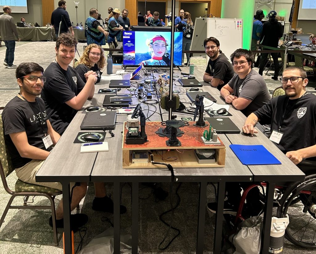 group of it professionals seated around table with laptops