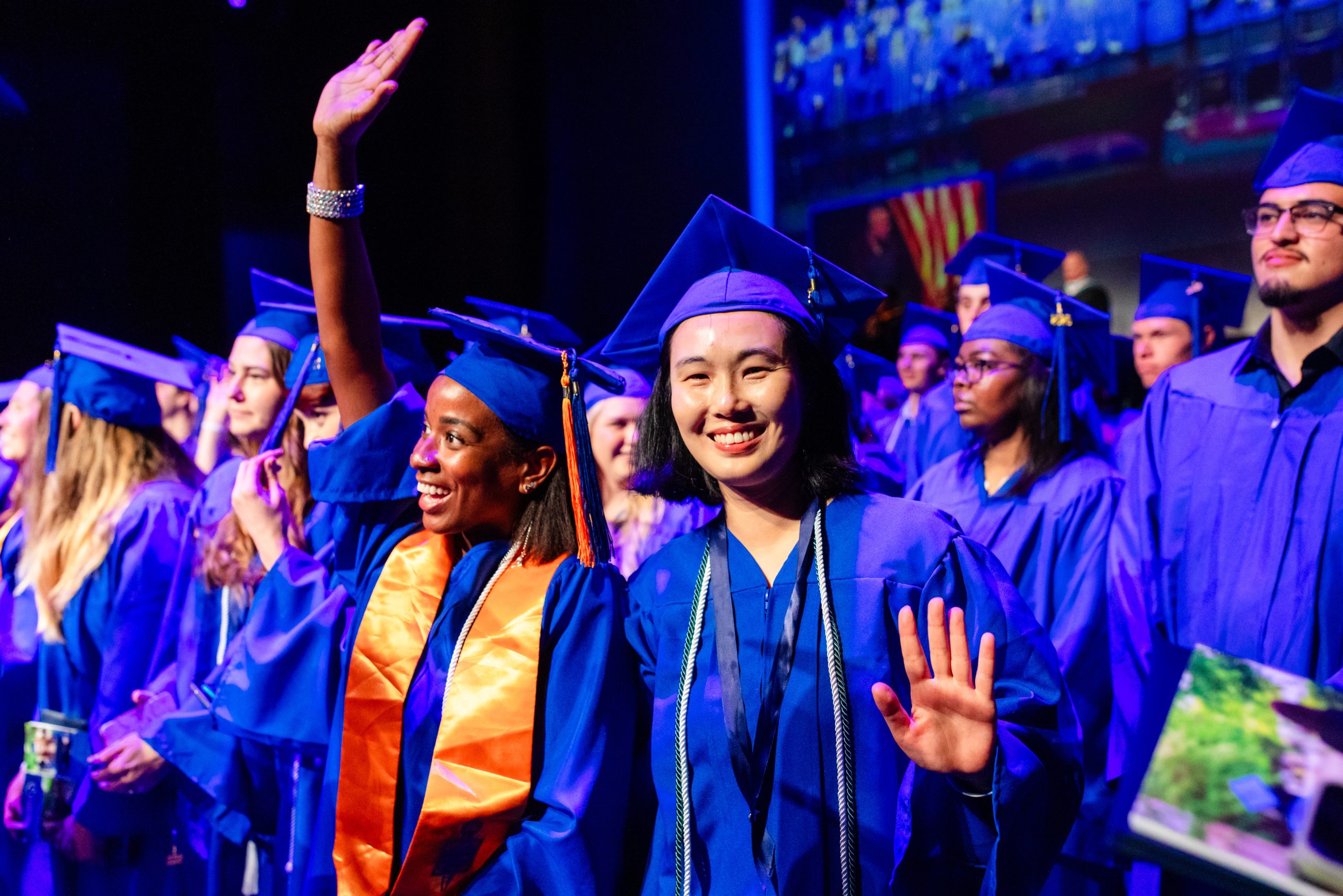 graduate smiling with other students at commencement