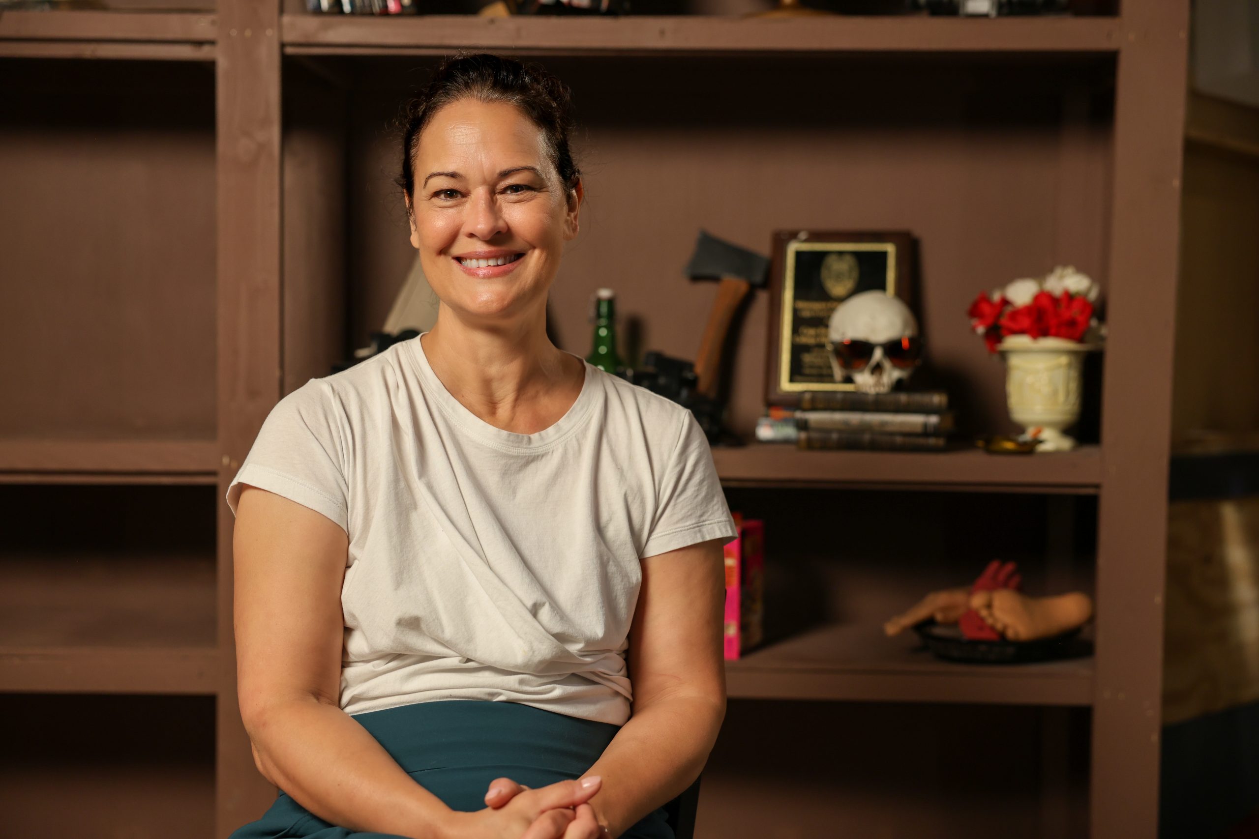 female seated behind bookshelves