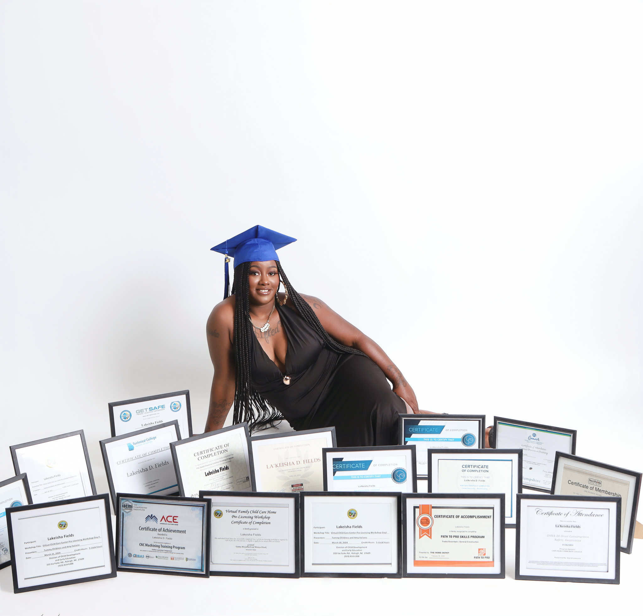 lakeisha sitting with all of her certificates behind a white background